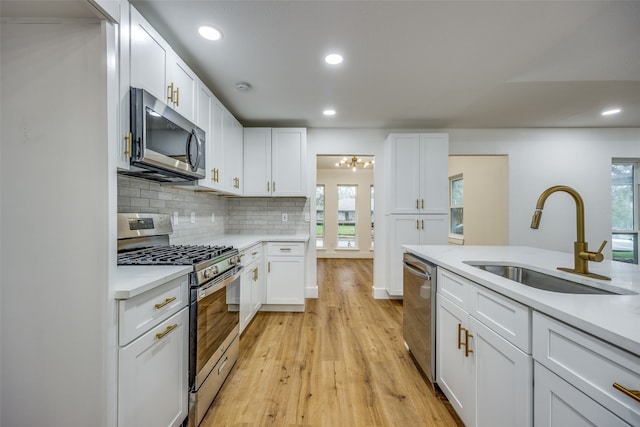 kitchen featuring white cabinets, light wood-type flooring, sink, and appliances with stainless steel finishes