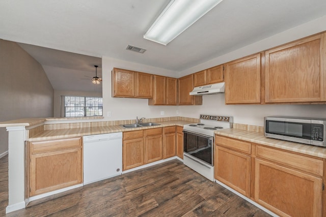 kitchen with lofted ceiling, white appliances, dark wood-type flooring, sink, and kitchen peninsula