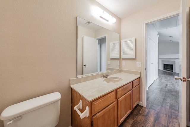 bathroom with vanity, hardwood / wood-style floors, and toilet