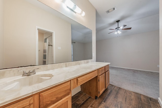 bathroom with ceiling fan, wood-type flooring, vanity, and lofted ceiling