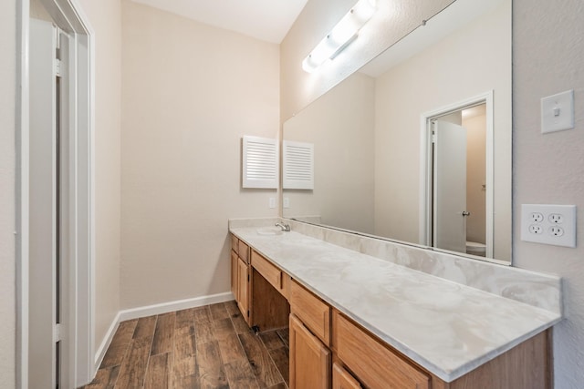 bathroom featuring vanity, wood-type flooring, and toilet