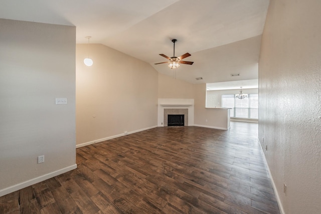 unfurnished living room with lofted ceiling, dark hardwood / wood-style floors, and ceiling fan with notable chandelier