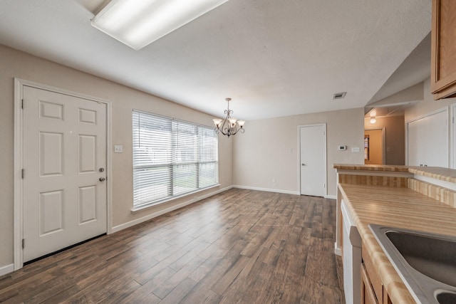 interior space featuring dark hardwood / wood-style flooring, decorative light fixtures, sink, and a notable chandelier