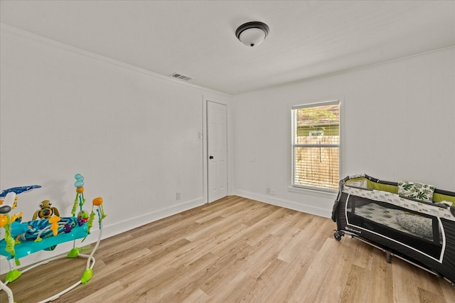 bedroom with light wood-type flooring and ornamental molding