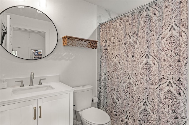 bathroom with walk in shower, vanity, and toilet