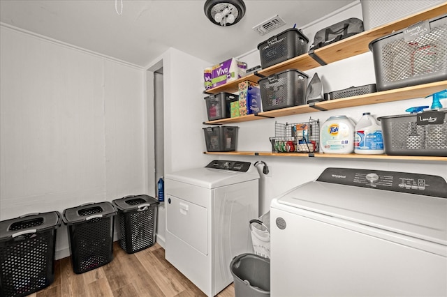 washroom with washing machine and dryer and light hardwood / wood-style flooring