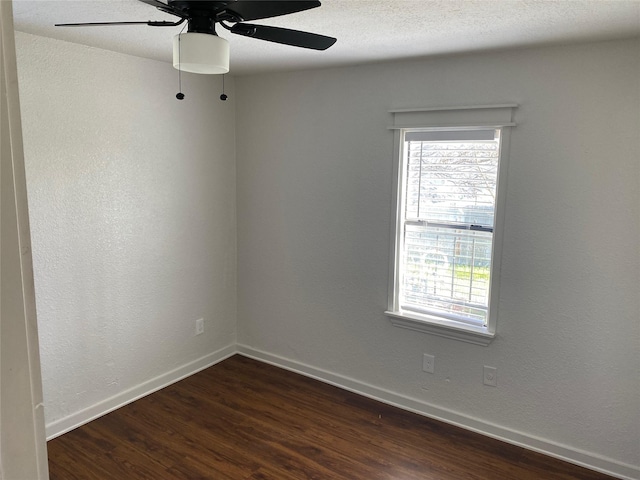 empty room featuring dark hardwood / wood-style flooring, ceiling fan, and a textured ceiling