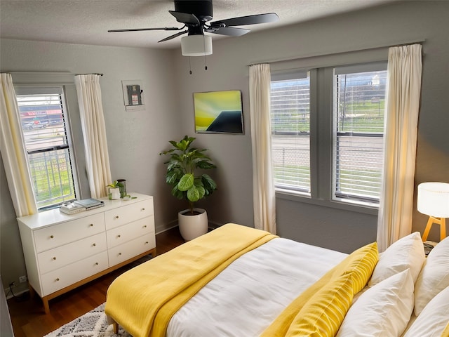 bedroom with dark hardwood / wood-style floors and ceiling fan