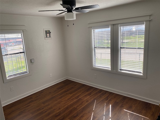 empty room with dark wood-type flooring, ceiling fan, and a textured ceiling