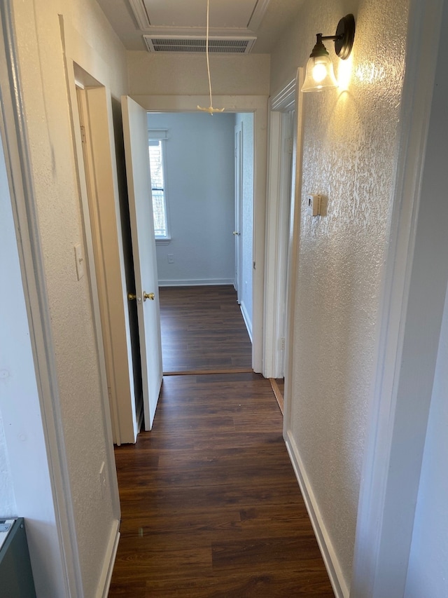 hallway with dark hardwood / wood-style flooring