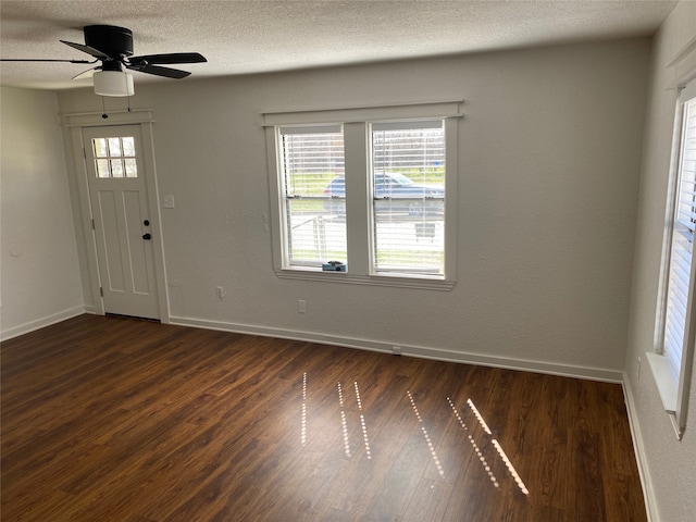 entrance foyer featuring dark wood-type flooring, ceiling fan, and a textured ceiling