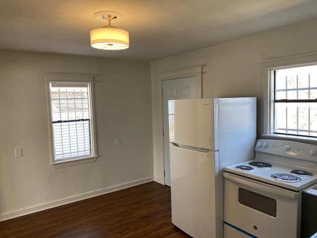 kitchen featuring white appliances and dark hardwood / wood-style floors