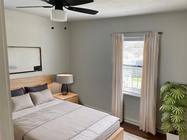 bedroom with hardwood / wood-style floors, a textured ceiling, and ceiling fan