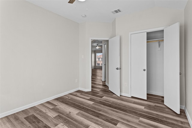 unfurnished bedroom with a closet, visible vents, dark wood-type flooring, a ceiling fan, and baseboards