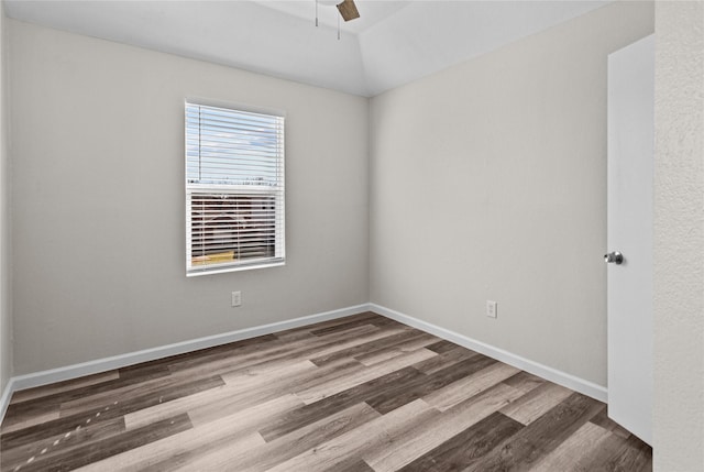 empty room featuring vaulted ceiling, ceiling fan, baseboards, and wood finished floors