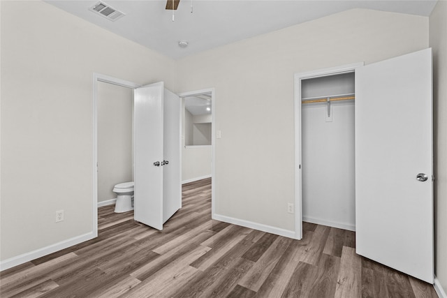 unfurnished bedroom featuring a closet, visible vents, baseboards, and wood finished floors