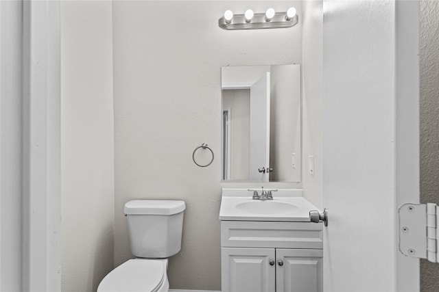 half bathroom with vanity and toilet