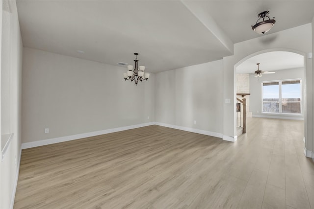 203 Half Moon Dr, Waxahachie, TX 75165 - spare room with arched walkways, ceiling fan with notable chandelier, baseboards, light wood-type flooring, and visible vents