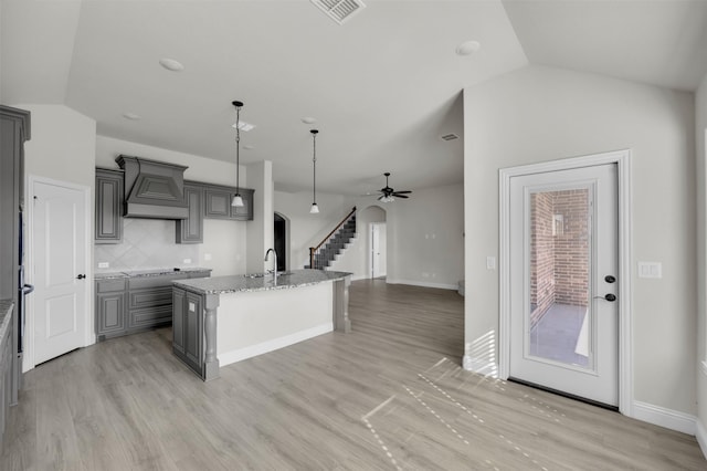 203 Half Moon Dr, Waxahachie, TX 75165 - kitchen featuring ceiling fan, gray cabinets, custom range hood, vaulted ceiling, and visible vents