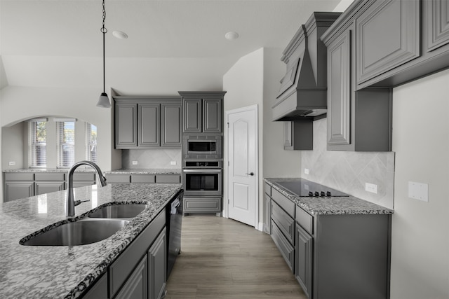 kitchen featuring custom exhaust hood, black appliances, sink, gray cabinets, and tasteful backsplash