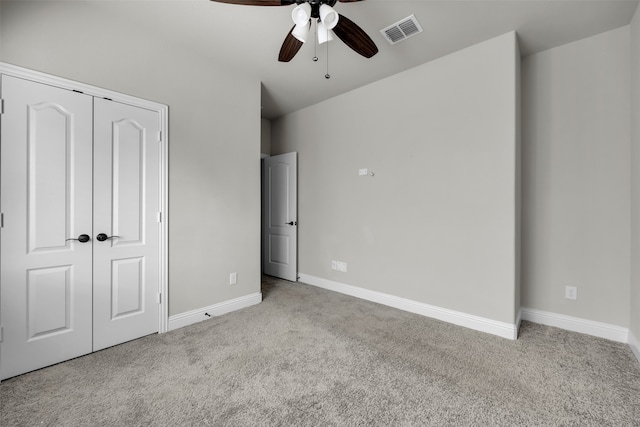 unfurnished bedroom featuring ceiling fan, light colored carpet, and a closet