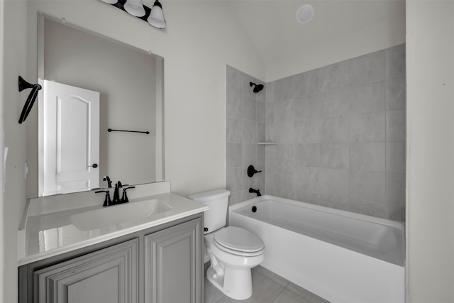 full bathroom with tile patterned floors, vaulted ceiling, toilet, vanity, and tiled shower / bath