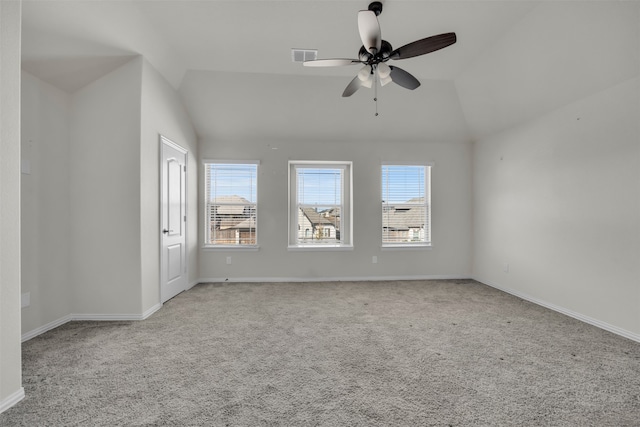 carpeted spare room featuring ceiling fan, a healthy amount of sunlight, and vaulted ceiling