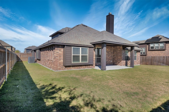 203 Half Moon Dr, Waxahachie, TX 75165 - back of house with a fenced backyard, a chimney, brick siding, a patio area, and a lawn