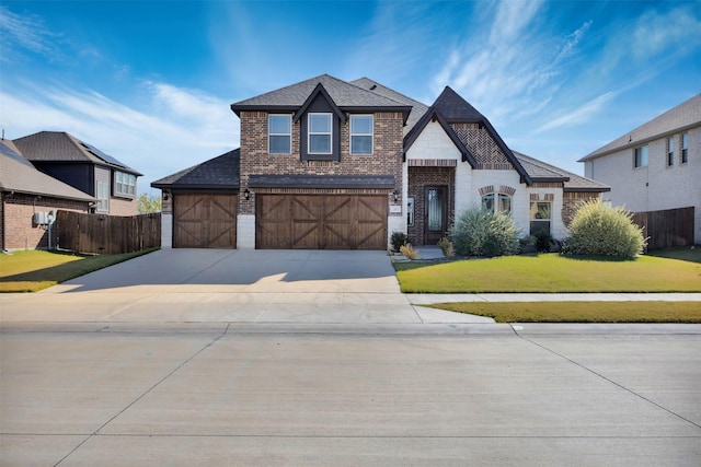 203 Half Moon Dr, Waxahachie, TX 75165 - view of front facade with a garage, brick siding, fence, a front lawn, and concrete driveway