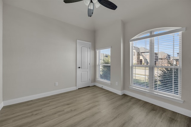 unfurnished room with ceiling fan, plenty of natural light, and light wood-type flooring