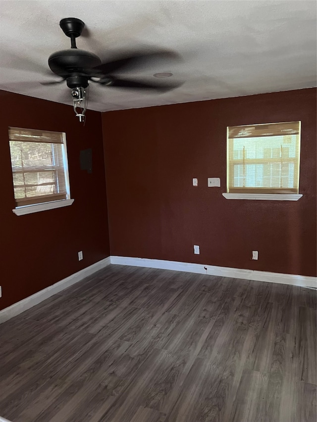 empty room featuring a textured ceiling, dark hardwood / wood-style floors, and ceiling fan