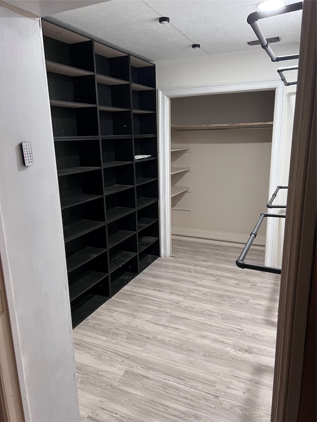 walk in closet with wood-type flooring