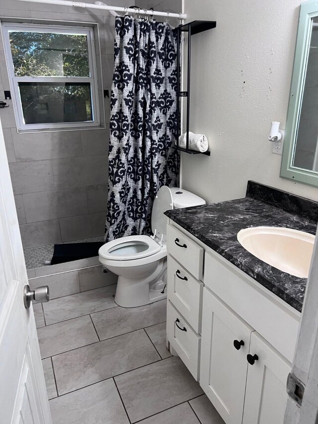 bathroom with tile patterned flooring, vanity, toilet, and a shower with curtain