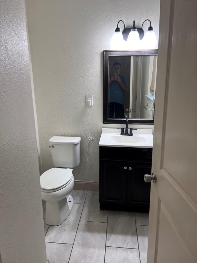 bathroom featuring vanity, tile patterned flooring, and toilet