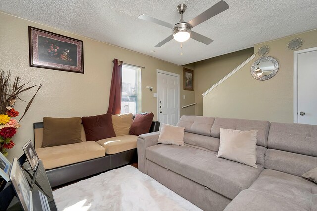 living room with ceiling fan and a textured ceiling