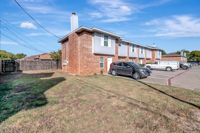 rear view of property featuring a lawn