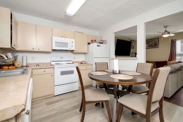 kitchen featuring white appliances, ceiling fan, sink, and light wood-type flooring