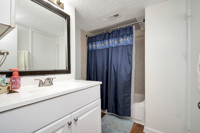 bathroom with shower / tub combo with curtain, vanity, a textured ceiling, and hardwood / wood-style flooring