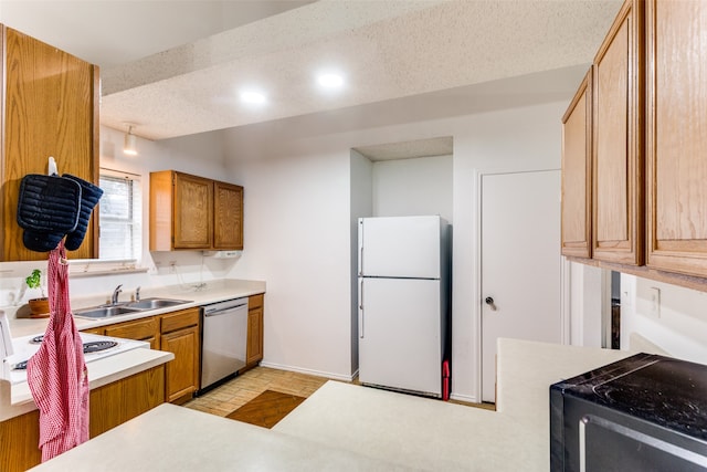 kitchen featuring stainless steel dishwasher, a textured ceiling, sink, and white refrigerator