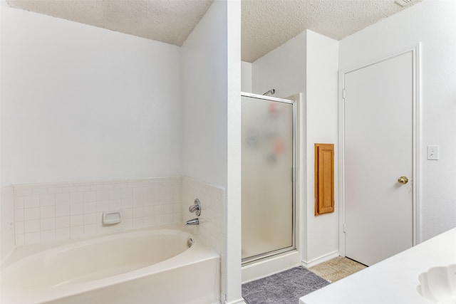 bathroom featuring shower with separate bathtub and a textured ceiling