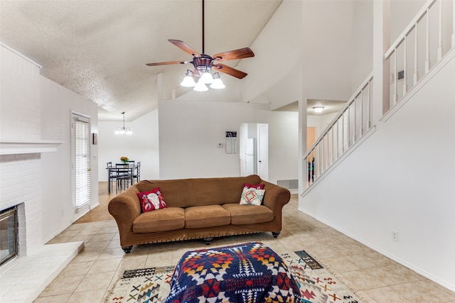 living room featuring high vaulted ceiling, a textured ceiling, light tile patterned floors, and a fireplace