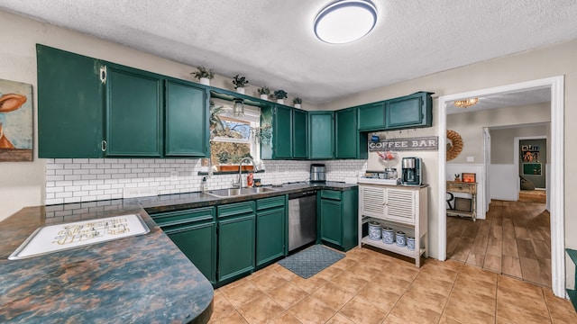 kitchen with green cabinets, sink, a textured ceiling, backsplash, and dishwasher