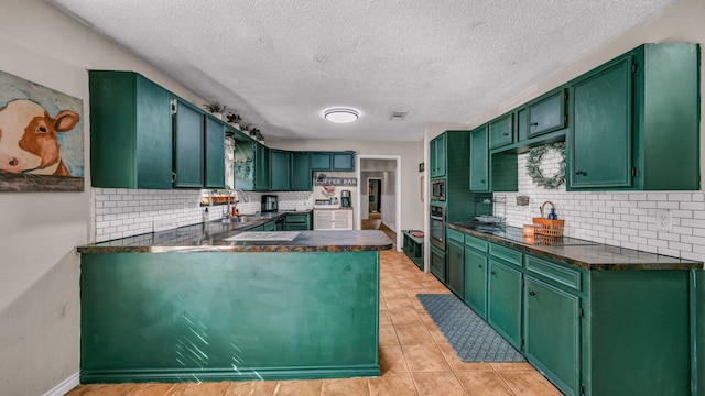 kitchen featuring green cabinetry, stainless steel appliances, a textured ceiling, and tasteful backsplash