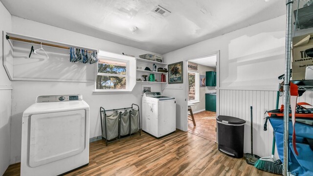 laundry area with wood-type flooring and washing machine and dryer