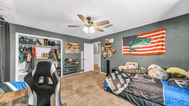 carpeted bedroom featuring a closet, a textured ceiling, and ceiling fan