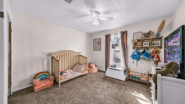 carpeted bedroom with a crib, ceiling fan, and a textured ceiling