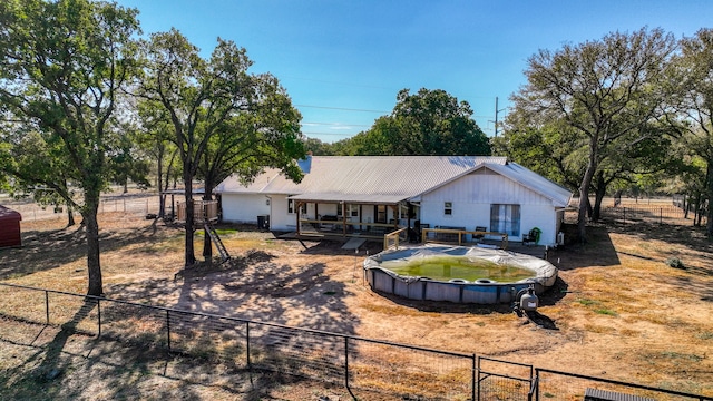 back of house featuring a covered pool