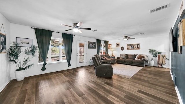 living room featuring ceiling fan and dark hardwood / wood-style flooring