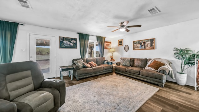 living room featuring ceiling fan and dark hardwood / wood-style floors