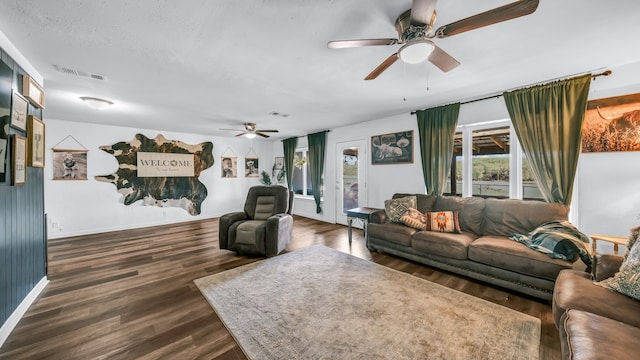 living room with plenty of natural light, dark wood-type flooring, and ceiling fan